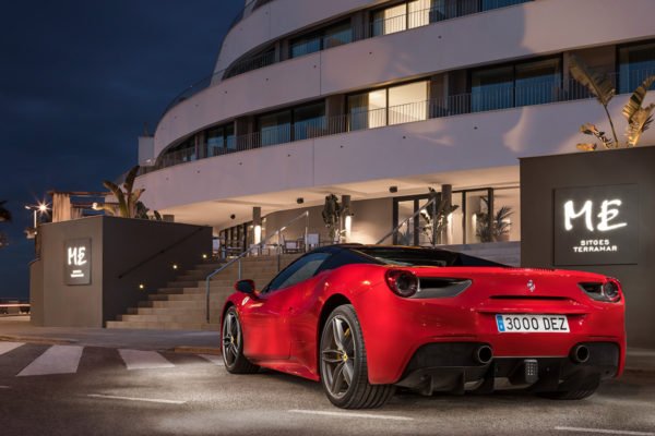 Coche deportivo de lujo delante de un hotel