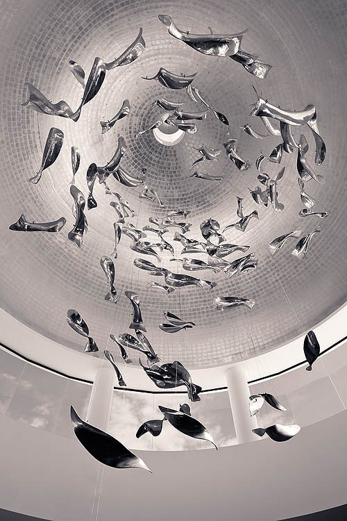 Escultura móvil con elementos recordando a peces